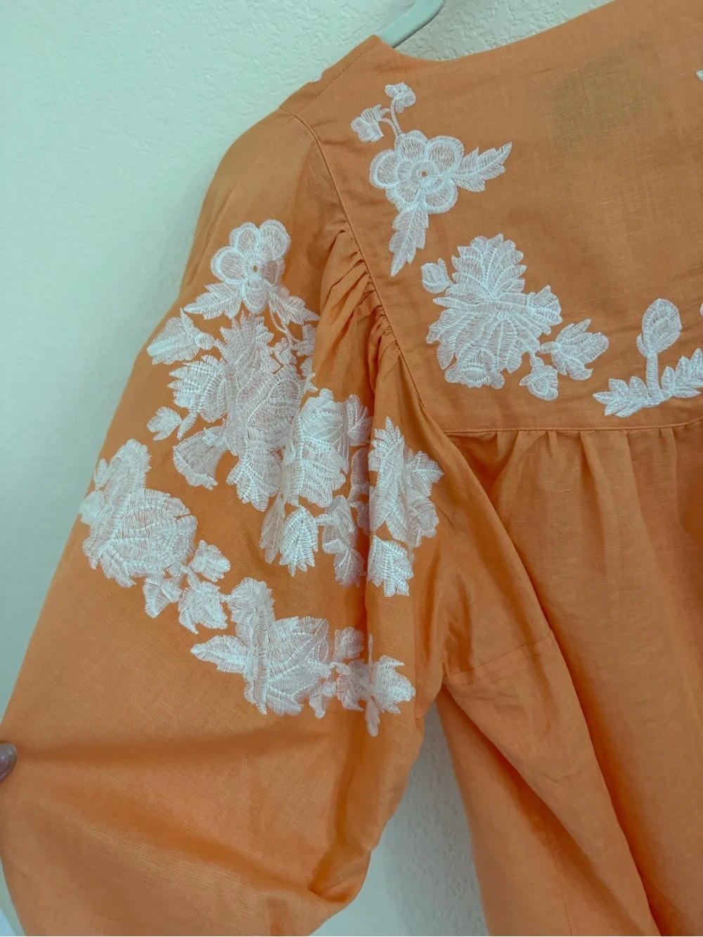 Blouse features split neckline with ties and voluminous embroidered puff sleeves